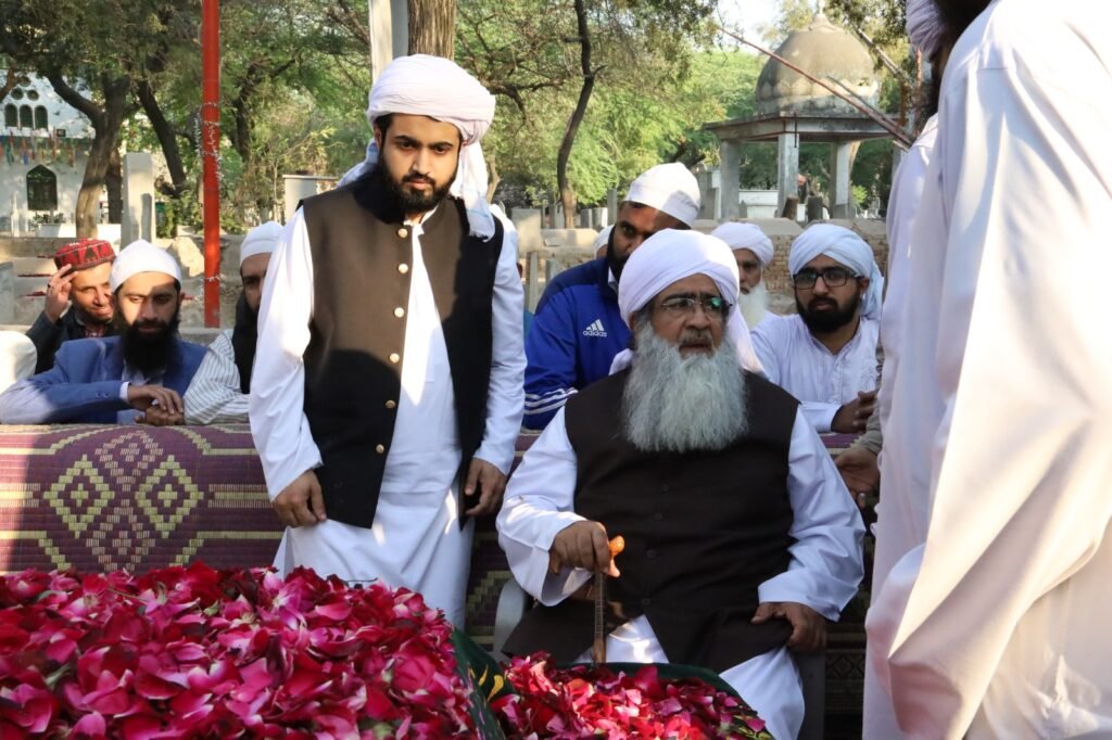 Shaykh Muhammad Mohsin Munawar Yousafi and Shaykh Muhammad Bin Mohsin Mohsini standing at a holy shrine or grave (Mazaar), emphasizing the scholarly lineage (Silsilah) and spiritual devotion.