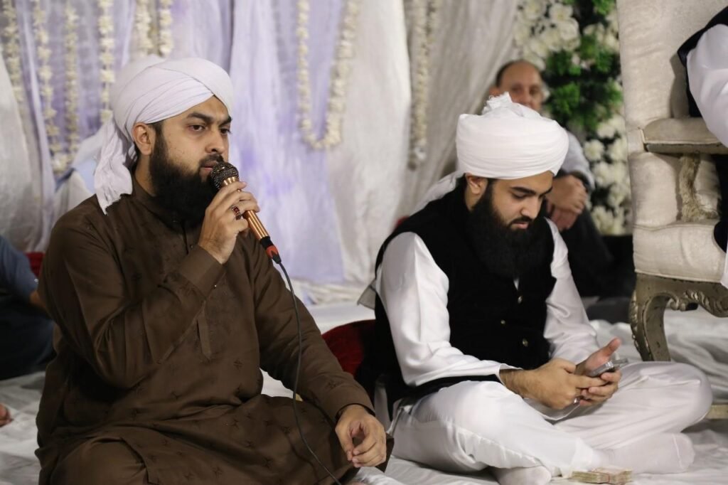 Shaykh Muhammad Mohsin Munawar Yousafi, the esteemed Islamic spiritual guide (Murshid), delivering a passionate discourse, seated and wearing a white turban and dark vest.