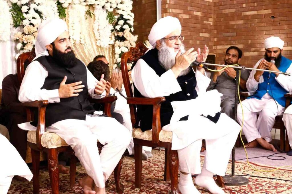 Shaykh Muhammad Mohsin Munawar Yousafi and Shaykh Muhammad Bin Mohsin Mohsini seated together on stage, participating in a joint religious address and scholarly discussion (Suhbah).